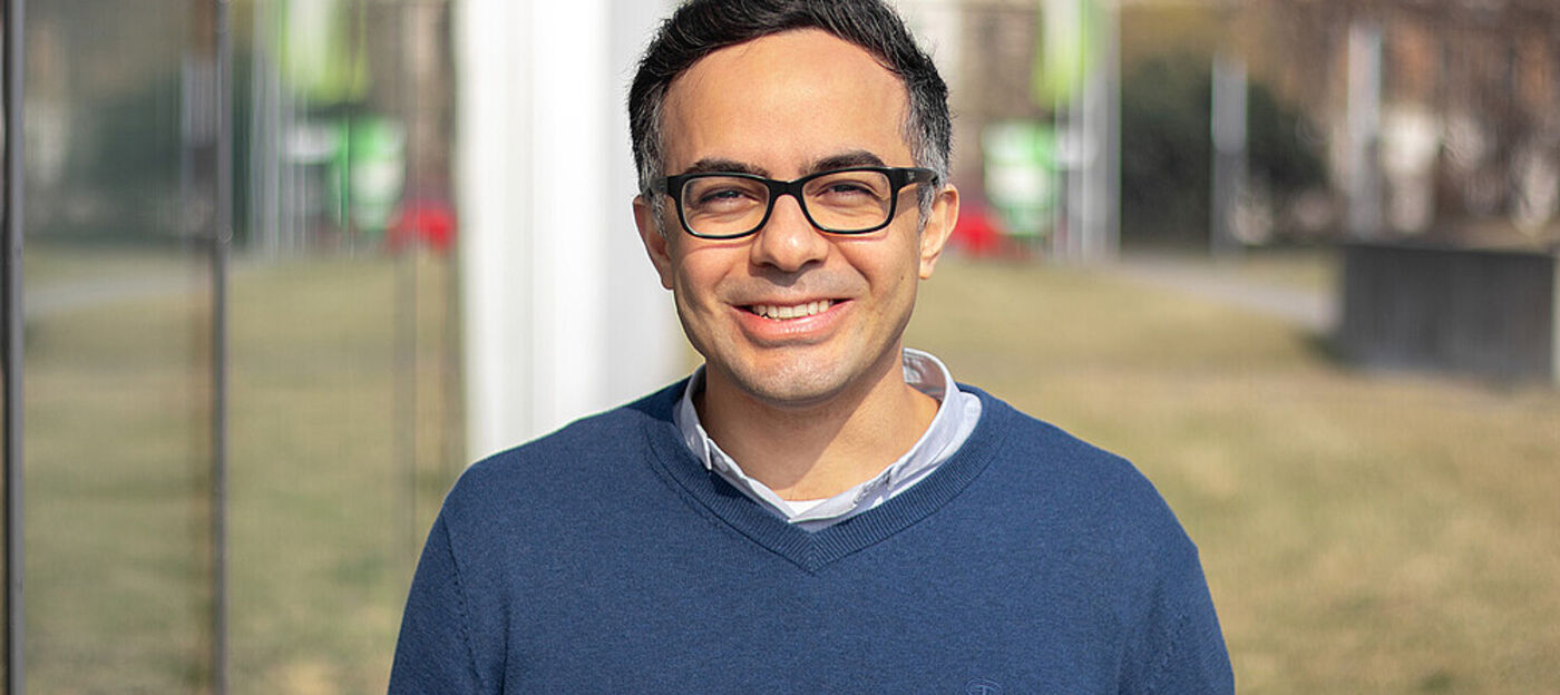 Man with glasses in front of a building