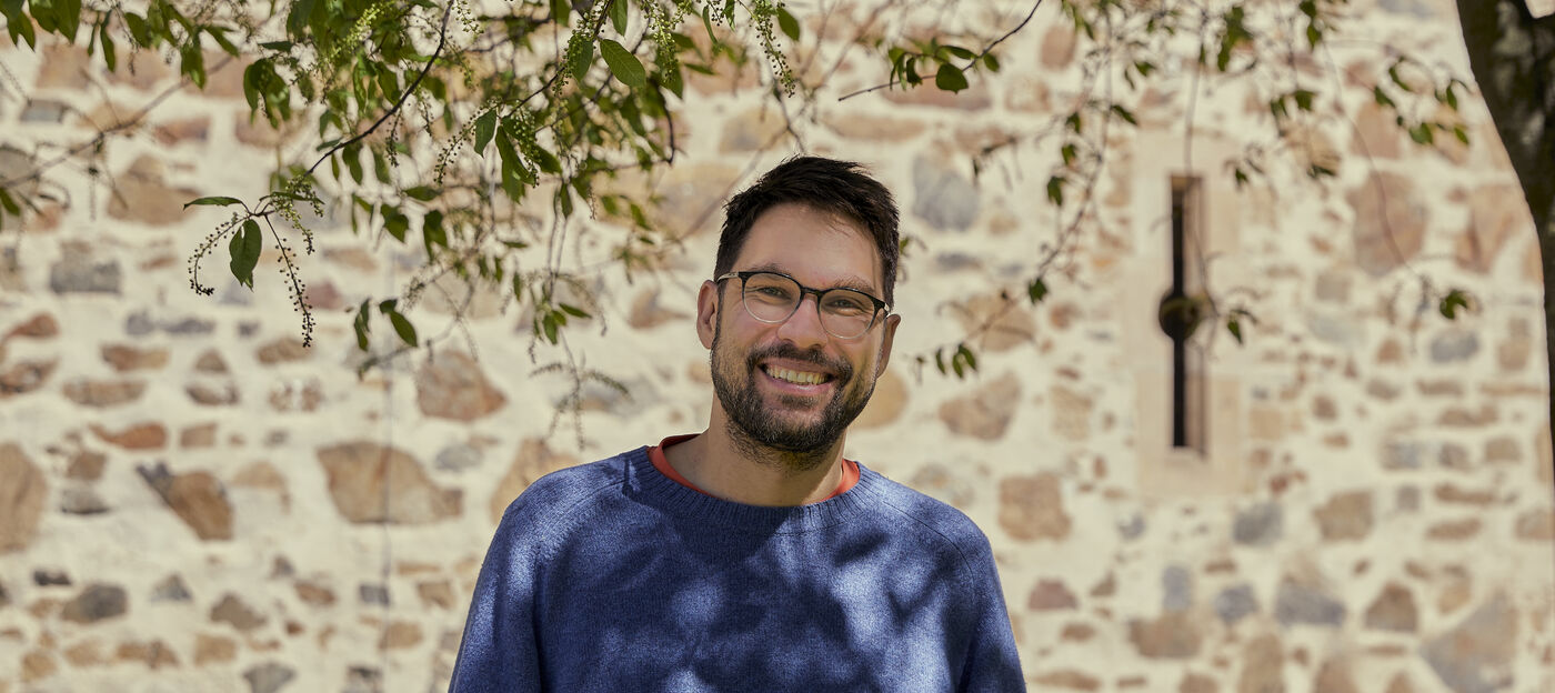 Man with glasses in front of a building