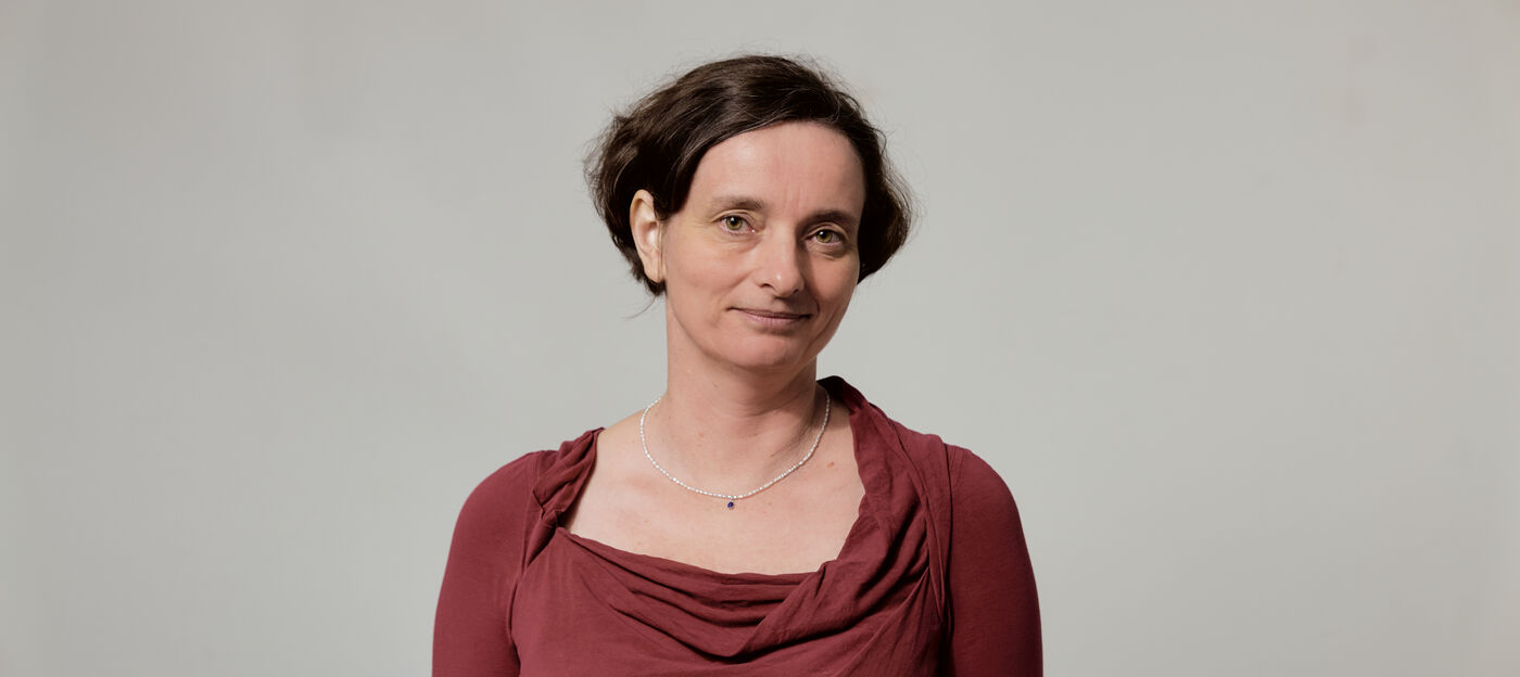 Frau mit kurzen Haaren vor einer Wand